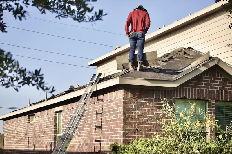 Professional roofer working on a residential roof in Alden Bridge